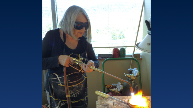 a woman wears goggles while welding